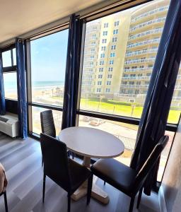 a room with a table and chairs and a large window at Oceanview Studio w/kitchen, pool, tiki bar in Daytona Beach