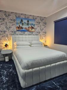 a white bed in a bedroom with a large white bedvisor at Boutique residential units in Sabkhah