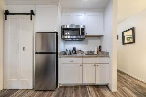 una cocina con nevera de acero inoxidable y armarios blancos en 111 Bldg B condo, en Truckee