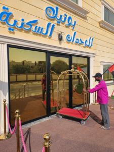 a man standing in front of a store with a playground at Boutique residential units in Sabkhah