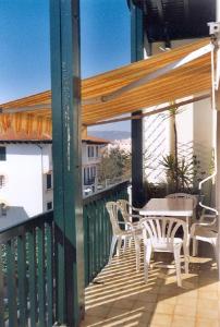 d'une terrasse avec une table et des chaises sur un balcon. dans l'établissement Duplex en Hendaye, à Hendaye