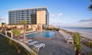 a hotel with a swimming pool next to the beach at Daytona Ocean View Modern Studio in Daytona Beach