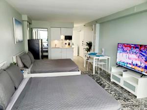 a living room with a large flat screen tv at Daytona Ocean View Modern Studio in Daytona Beach