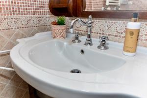 a white sink in a bathroom with a plant on it at RobertONE guest house 14 in Bari +9 photos