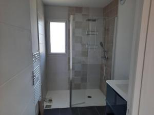 ein Badezimmer mit einer Glasdusche mit Waschbecken in der Unterkunft Maison 6 personnes in Saint-Méloir-des-Ondes