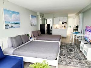 a living room with a bed and a kitchen at Daytona Ocean View Modern Studio in Daytona Beach