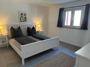 ein weißes Sofa in einem Zimmer mit Fenster in der Unterkunft Ferienwohnung Seescheune 150m vom Ufer entfernt in Bodman-Ludwigshafen