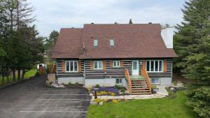 a large house with a porch and a driveway at Le Pimbina in Mont-Tremblant