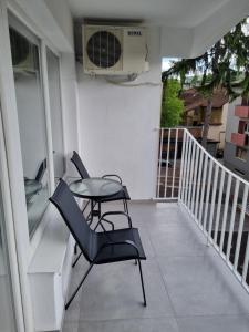 balcón con 2 sillas, mesa y ventilador en Nika-Simka, en Banja Luka