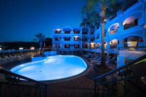 una piscina en un complejo por la noche en Zante Atlantis Hotel, en Laganas