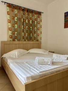 a bedroom with a large white bed with a curtain at Vila Eqerem Dauti Ksamil in Ksamil