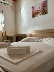 a white bed with two towels on top of it at Vila Eqerem Dauti Ksamil in Ksamil