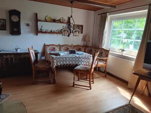 a dining room with a table and chairs and a window at Sonnenscheinhof Alpakas, Ferienwohnung in Lasbek