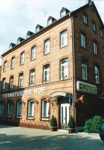 un gran edificio de ladrillo rojo con un cartel. en Hotel Frankfurter Hof, en Limburg an der Lahn