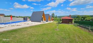 a green yard with a row of houses and a building at Wild A-frame in Baile Felix