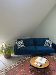 a blue couch in a living room with a table at Maison Tassigny in Meursault