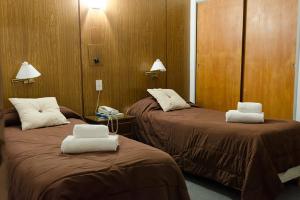 a hotel room with two beds with towels on them at Hotel Cipolletti in Cipolletti