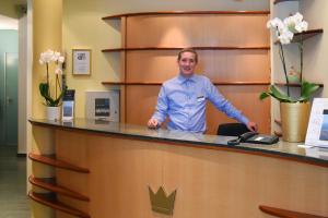 a man standing at a reception desk in a room at Altstadt Hotel Krone Luzern in Lucerne