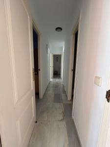 an empty hallway with white walls and a long corridor at Piso Tamaragua in Arrecife