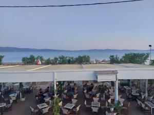 eine Außenterrasse mit Menschen, die auf Stühlen und Tischen sitzen. in der Unterkunft Constantina in Skala Kallonis + 7 Fotos