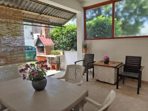 a patio with a table and chairs and a bird house at Guesthouse Trogir Proto-Free parking in Trogir