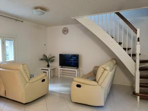 un soggiorno con 2 sedie e una TV di Villa Perttilä 