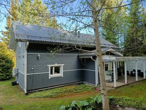una casa grigia con un portico e un albero di Villa Perttilä 