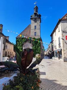 a statue in the middle of a street with a clock tower at L'appart des vignes in Nuits-Saint-Georges