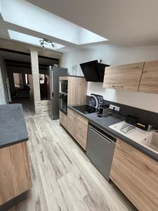 a large kitchen with wooden cabinets and appliances at L'appart des vignes in Nuits-Saint-Georges