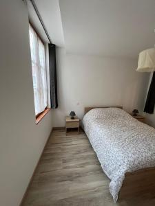 a bedroom with a bed and a window at L'appart des vignes in Nuits-Saint-Georges