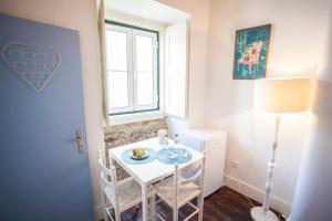 Una pequeña mesa blanca en una habitación con ventana en Lisbon Inn Bica Suites, en Lisboa