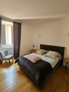 a bedroom with a bed and a chair and a window at superbe appartement de prestige avec vue mer in Bastia