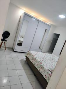 ein Schlafzimmer mit einem Bett und einem Spiegel in der Unterkunft Apartamento in Campina Grande
