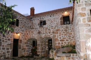 ein altes Steingebäude mit Fenstern und einem Innenhof in der Unterkunft Stone House Varoš in Starigrad-Paklenica
