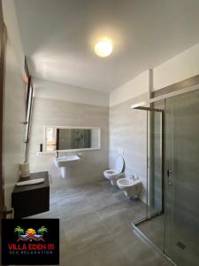 都拉斯Villa Eden 111, Perla Resort, Bay of Lalzi的浴室设有2个卫生间、2个盥洗盆和淋浴。