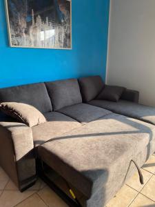 a couch in a living room with a blue wall at Appartamento 550 mt dal mare in Punta Marina