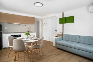 a living room with a table and a blue couch at Forest Hill Apartment, near Ljubljana in Dol pri Ljubljani