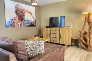 a living room with a couch and a flat screen tv at Villa Tanzanie - Domaine Le Sherwood in Notre-Dame-de-Monts +5 photos