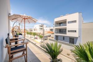 a balcony with an umbrella and a view of a street at Diamante Del Mar Thalia and Erato in Kos