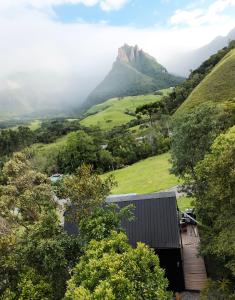 a house in a valley with a mountain in the background at Cabana do Céu - Soldados Sebold in Alfredo Wagner