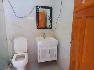 a bathroom with a white toilet and a mirror at Gnanam Villa in Nikawatawana +4 photos