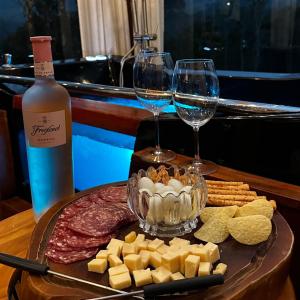 a tray with wine glasses and cheese and crackers at Cabana do Céu - Soldados Sebold in Alfredo Wagner