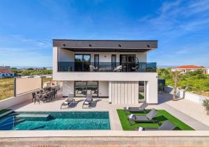 a house with a swimming pool in front of it at NEW! Luxury Villa Golden Hour near the beach with heated pool and sauna - TA Leut agency in Privlaka