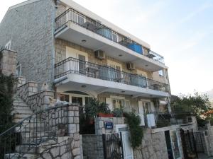 an apartment building with stairs and a balcony at Apartments Mitrovići Miločer in Sveti Stefan
