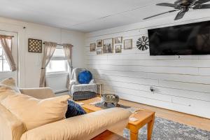 a living room with a couch and a tv at Lake and Mtn Views Vermont Couples Retreat! in Barton