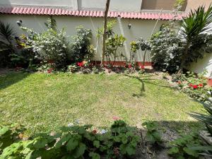 a garden with flowers and plants in front of a house at Departamento Primer Piso - Embajada USA in Lima