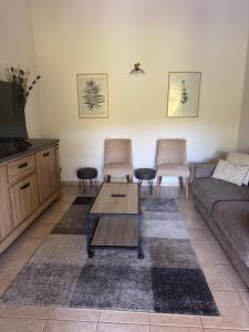a living room with a couch and two chairs at Mini villa proche plage Santa Giulia in Porto-Vecchio