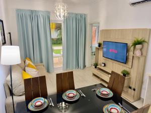 ein Wohnzimmer mit einem Esstisch und einem TV in der Unterkunft Casa Mulata Coral Village Pool & Playa in Punta Cana