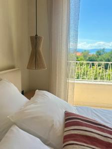 a bedroom with a bed and a window with a view at Villa Olea Mare Mediterranean Comfort & Style in Malinska