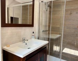 a bathroom with a sink and a glass shower at Carmen Luxury House in Muros